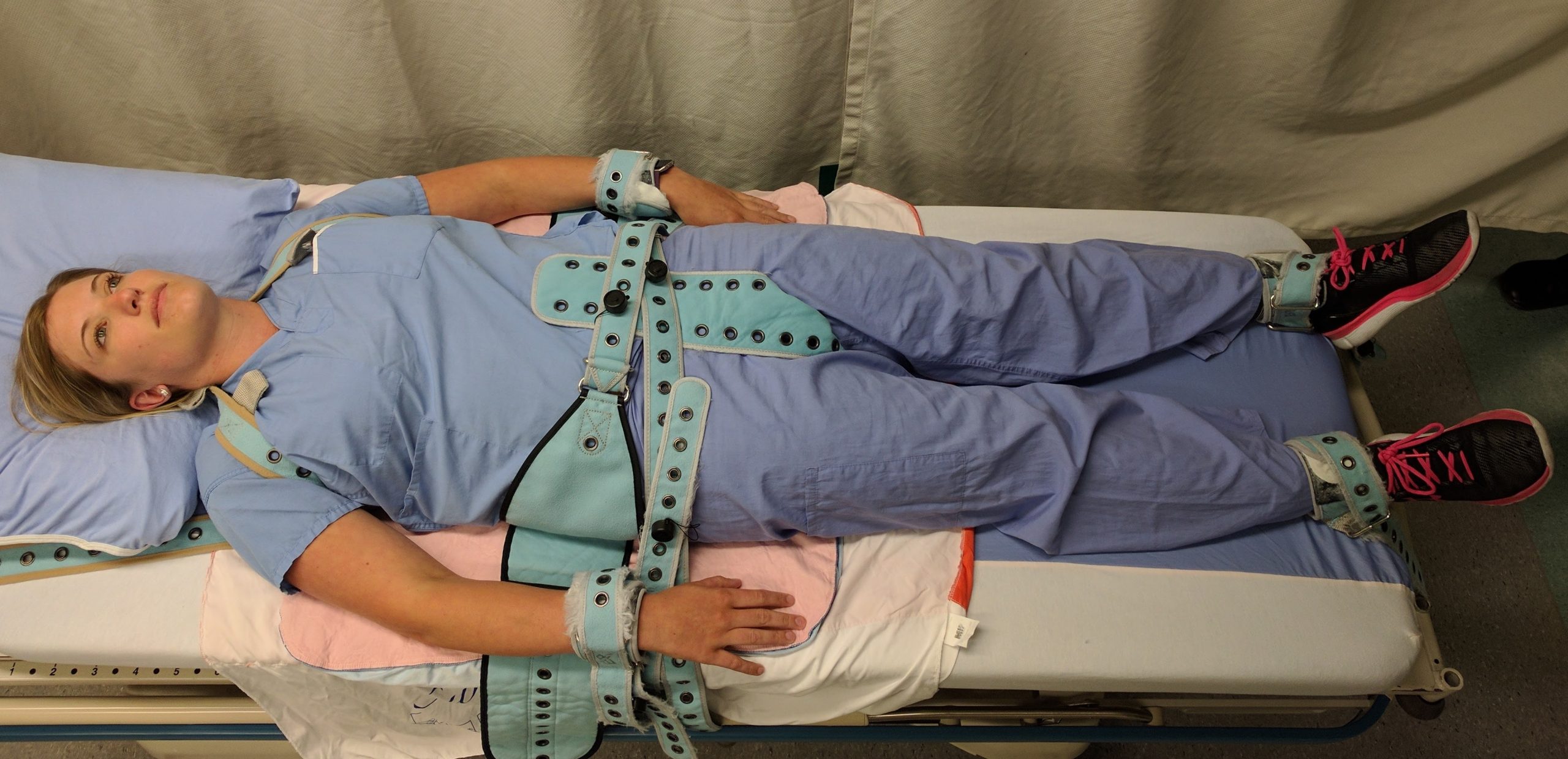 “PinelRestraint.jpg” by James Heilman, MD is licensed under CC BY-SA 4.0 Photo showing simulated patient in pinel restraint