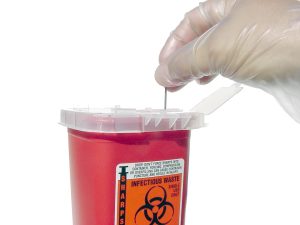 “Sharps Container.jpg” by William Rafti of the William Rafti Institute CC BY 2.5 Photo showing a gloved hand placing a metal tip into a sharps container