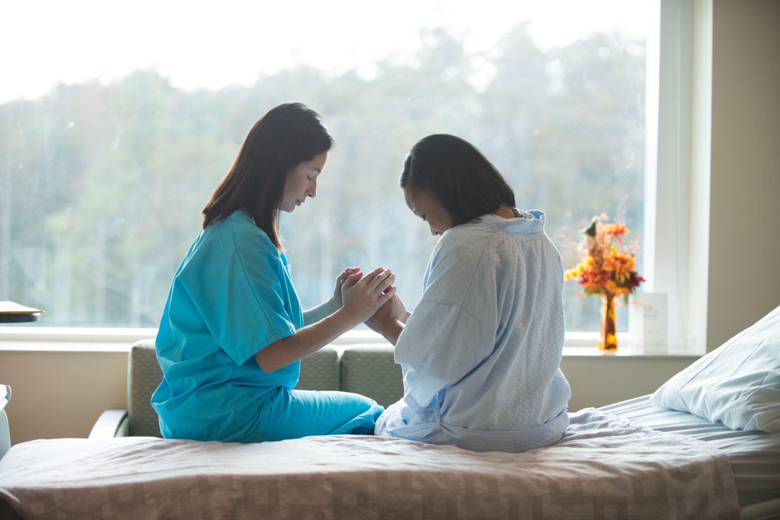“Praying_with_Patient.jpg” by Ahs856 is licensed under CC BY-SA 4.0 Image showing a Nurse Praying with a Patient