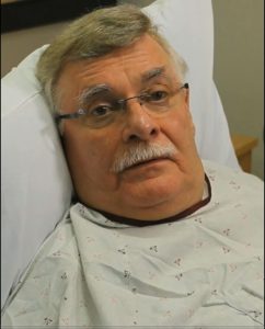 / Image of an older male in a hospital gown