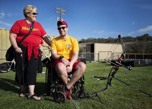 “140305-M-KL110-002_(13063045524).jpg” by U.S. Department of Defense Current Photos is licensed under CC0 Image showing a woman standing next to a man in a wheelchair