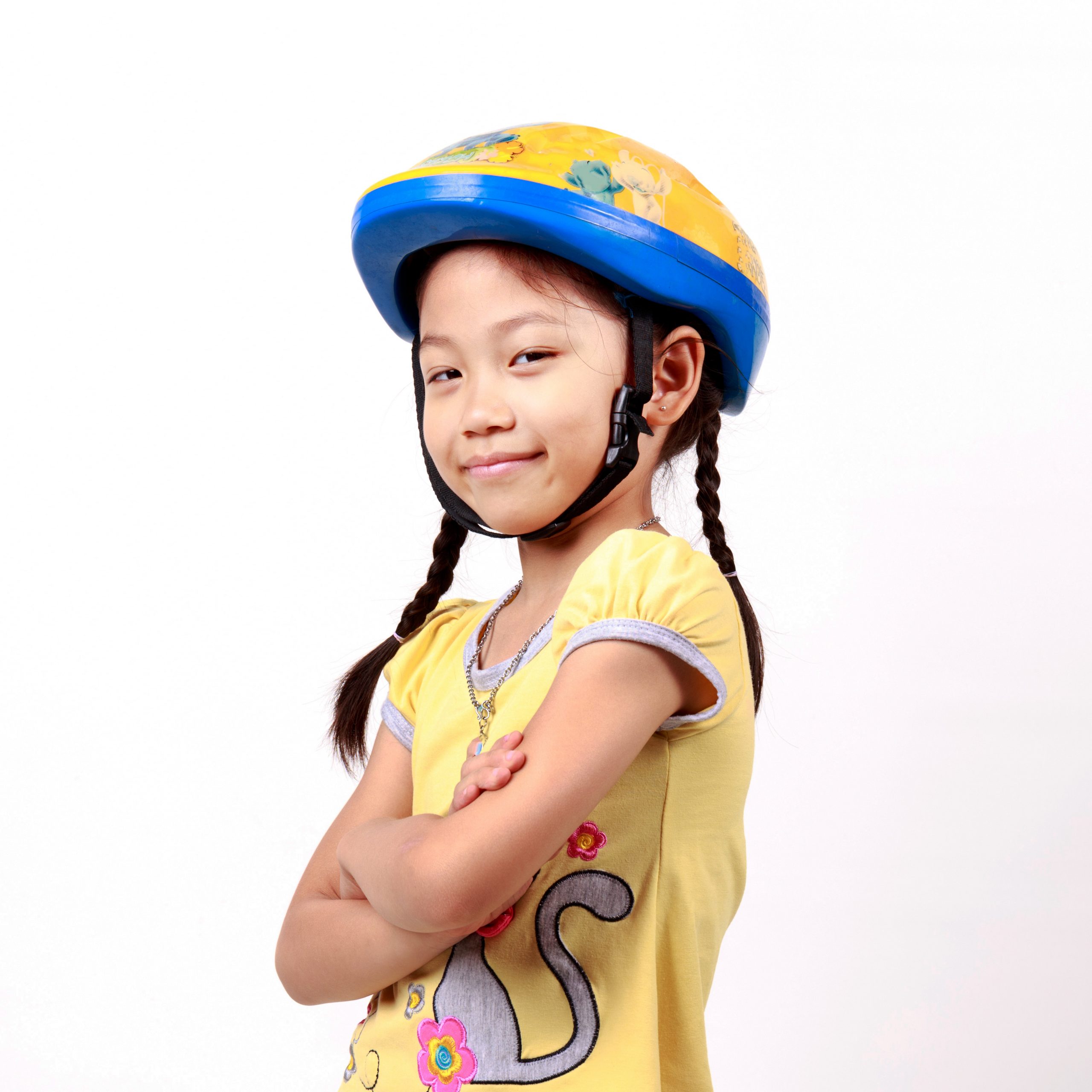 “539478754.jpg” by thechatat is used under license from Shutterstock.com Image of young girl, with crossed arms, wearing a bicycle helmet and smiling