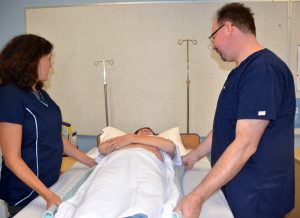 “Book-pictures-2015-572.jpg” by unknown author is licensed under CC BY 4.0. Access for free at https://opentextbc.ca/clinicalskills/chapter/3-5-positioning-a-patient-on-the-side-of-a-bed/ Image showing two nurses moving a simulated patient up in a bed