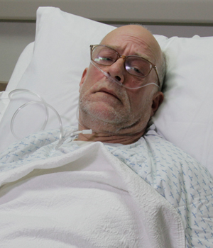 "Hospitalized Male“ by ARISE project is licensed under CC BY 4.0 Image of a simulated patient looking camera