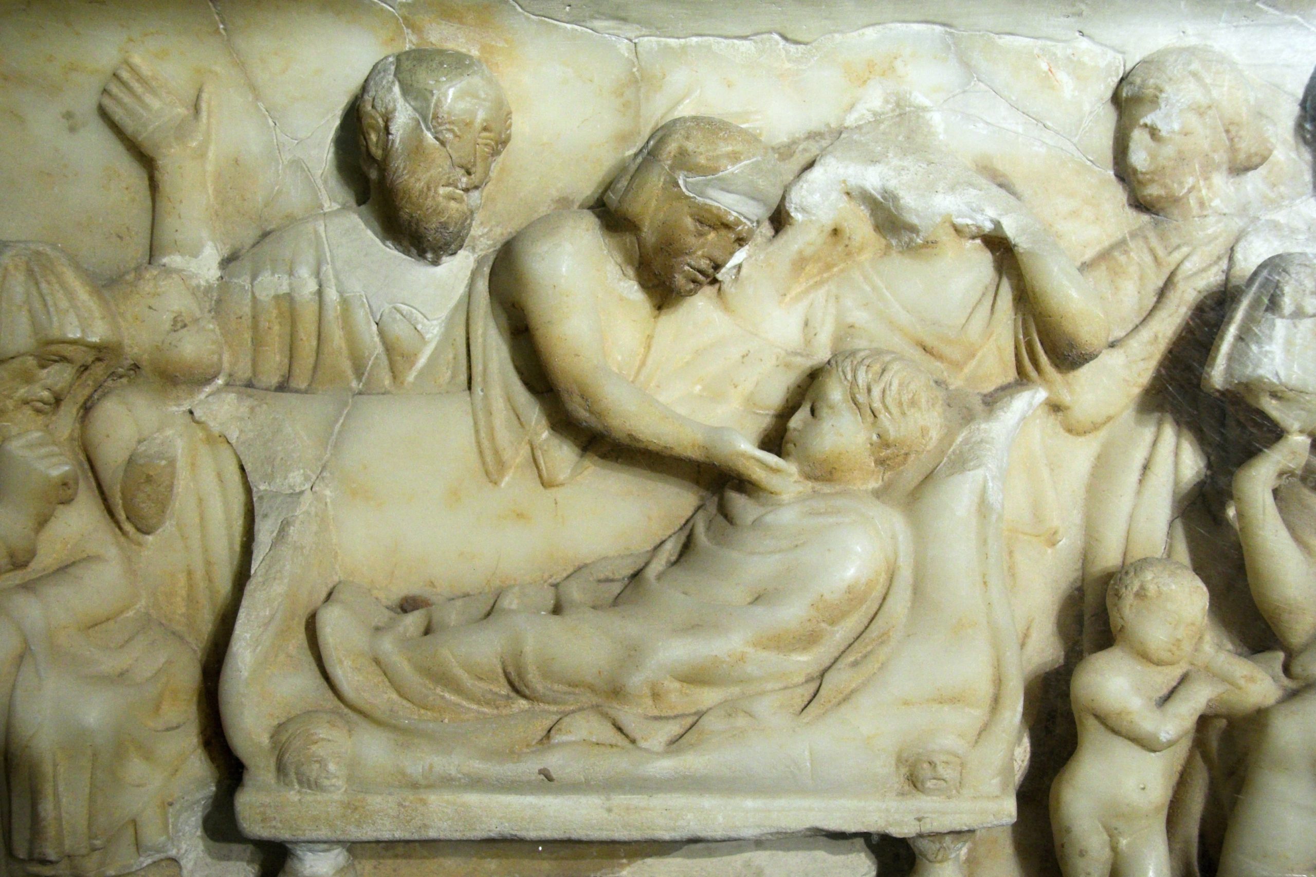 “Sarcophagus,_marble,_mourning_for_child,_100-200_AD,_AM_Agrigento,_121062.jpg” by Zde is licensed under CC BY-SA 4.0 Image shouwing Sarcophagus in marble, decorated in relief on three sides for a child. Mourning scene for a child.
