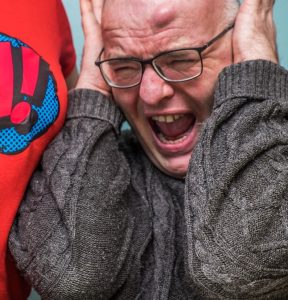 “Sensory_Overload.jpg” by Stewart Black is licensed under CC BY 2.0 Photo showing person in distress from sensory overload