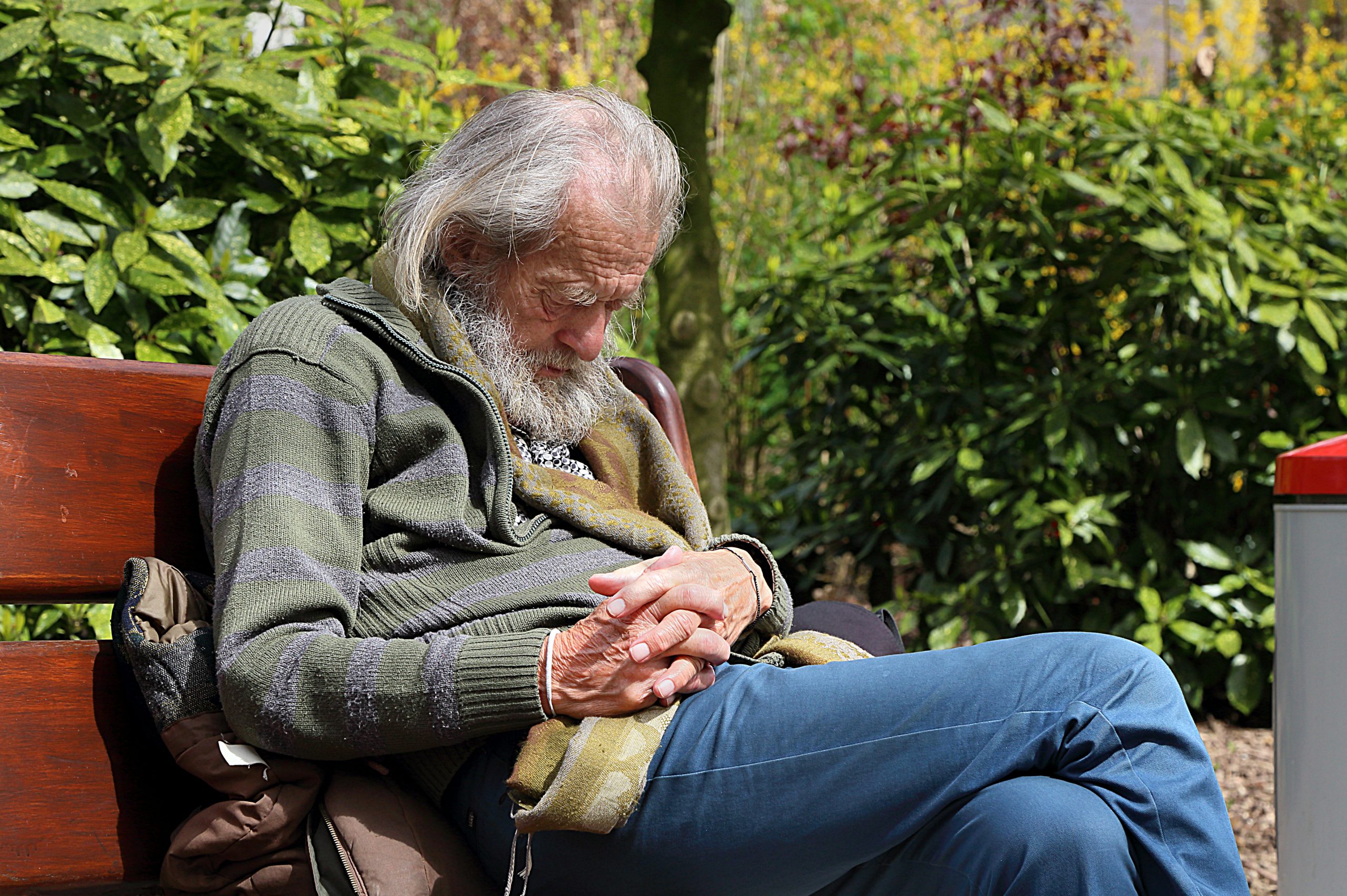 “Sleeping_man_J2.jpg” by Jamain is licensed under CC BY-SA 3.0 Image of elderly man sleeping on a park bench
