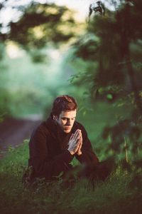 “meditation-1350599_960_720.jpg” by brenkee is licensed under CC0 Image showing person praying in wooded area