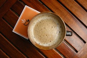 Image of coffee in a brown cup on a wooden table