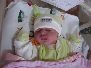 Photo of a baby in a hospital crib.