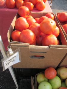 Image of a cardboard box full of Creole tomatoes at New Orleans' Uptown Farmers Market