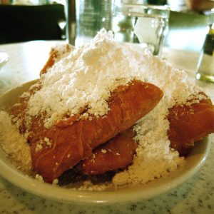 Image of a plate of beignets with powdered sugar on top at Cafe Du Monde in New Orleans, Louisiana