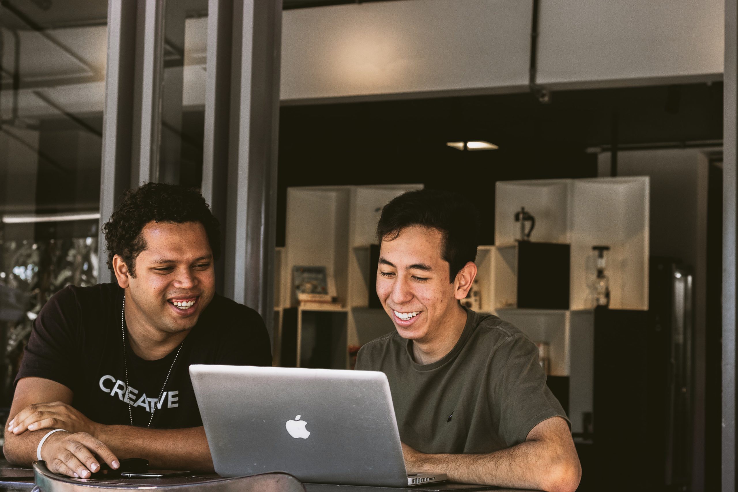 Two Men smiling at a laptop