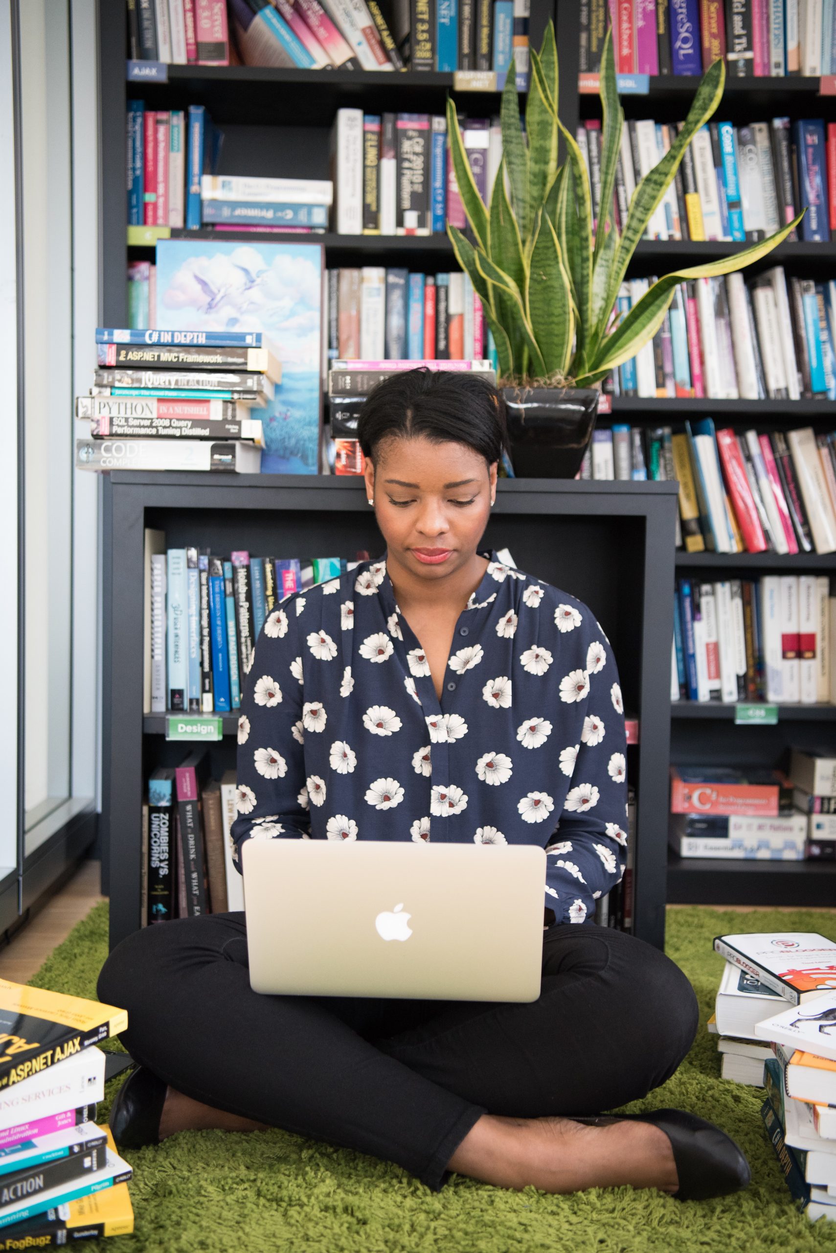 woman siting on the floor while working on a laptop