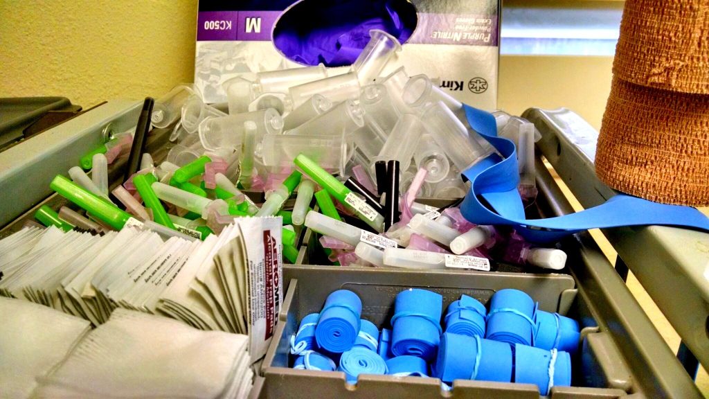 Blood draw supplies including alcohol prep pads, gauze, and tourniquets.
