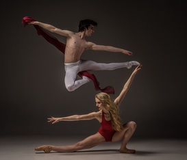 Male and female dancers demonstrating the use of space as the male dancer leaps over the female.