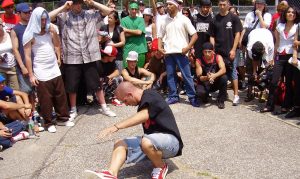 A photograph of an individual break dancing in the street.