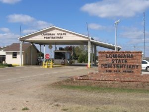 Entrance to Louisiana State Penitentiary with a white canopy and brick sign.
