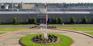 United States high security penitentiary at Pollock, Louisiana. Showing the correctional facility entrance with a flagpole and landscaped garden.
