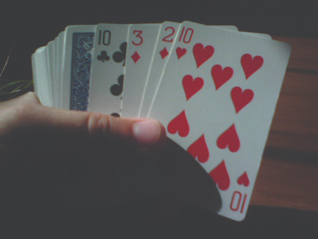 The figure shows someone holding a deck of cards.