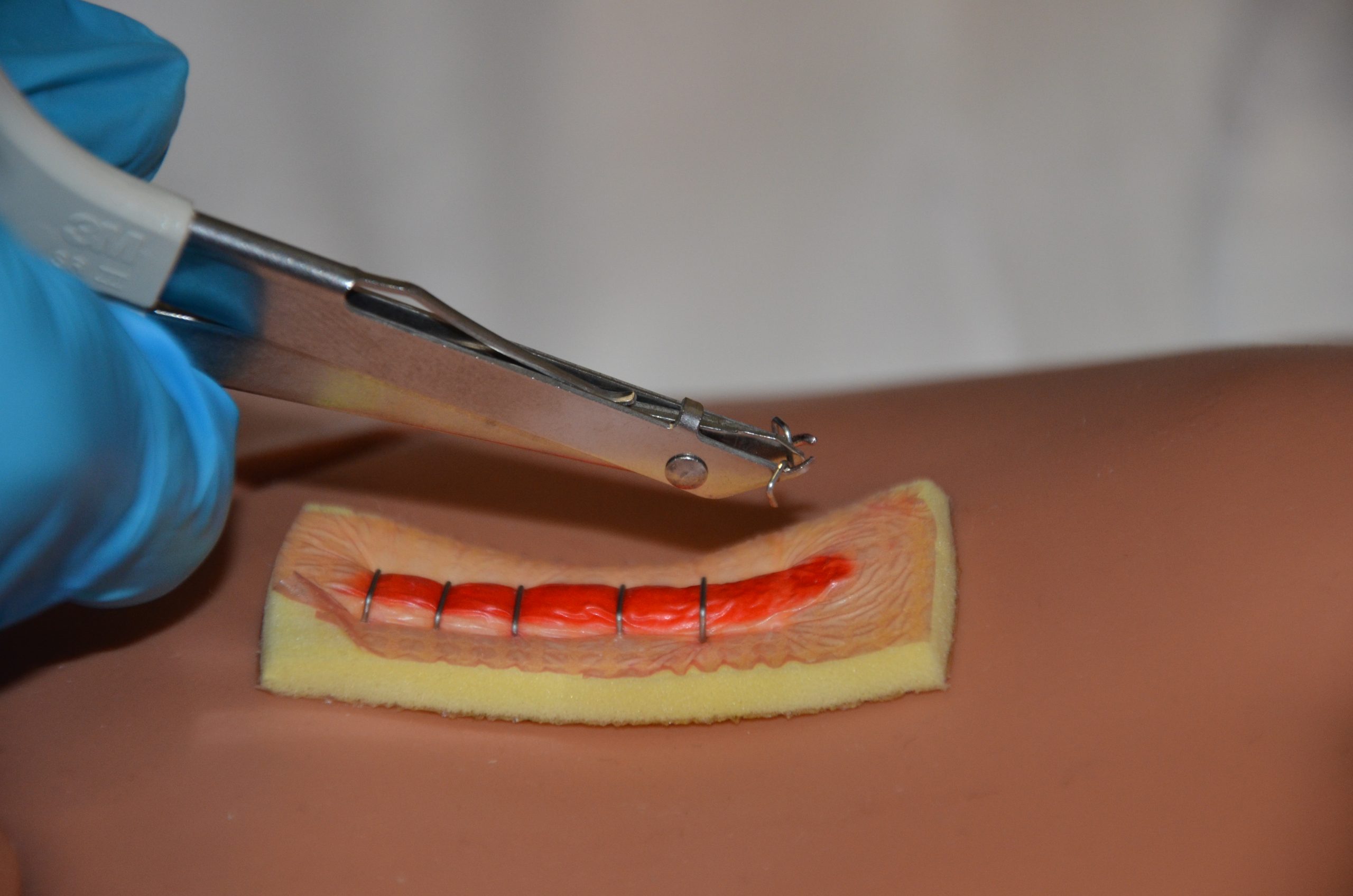 Keep the handle closed and move the staple extractor away from the skin