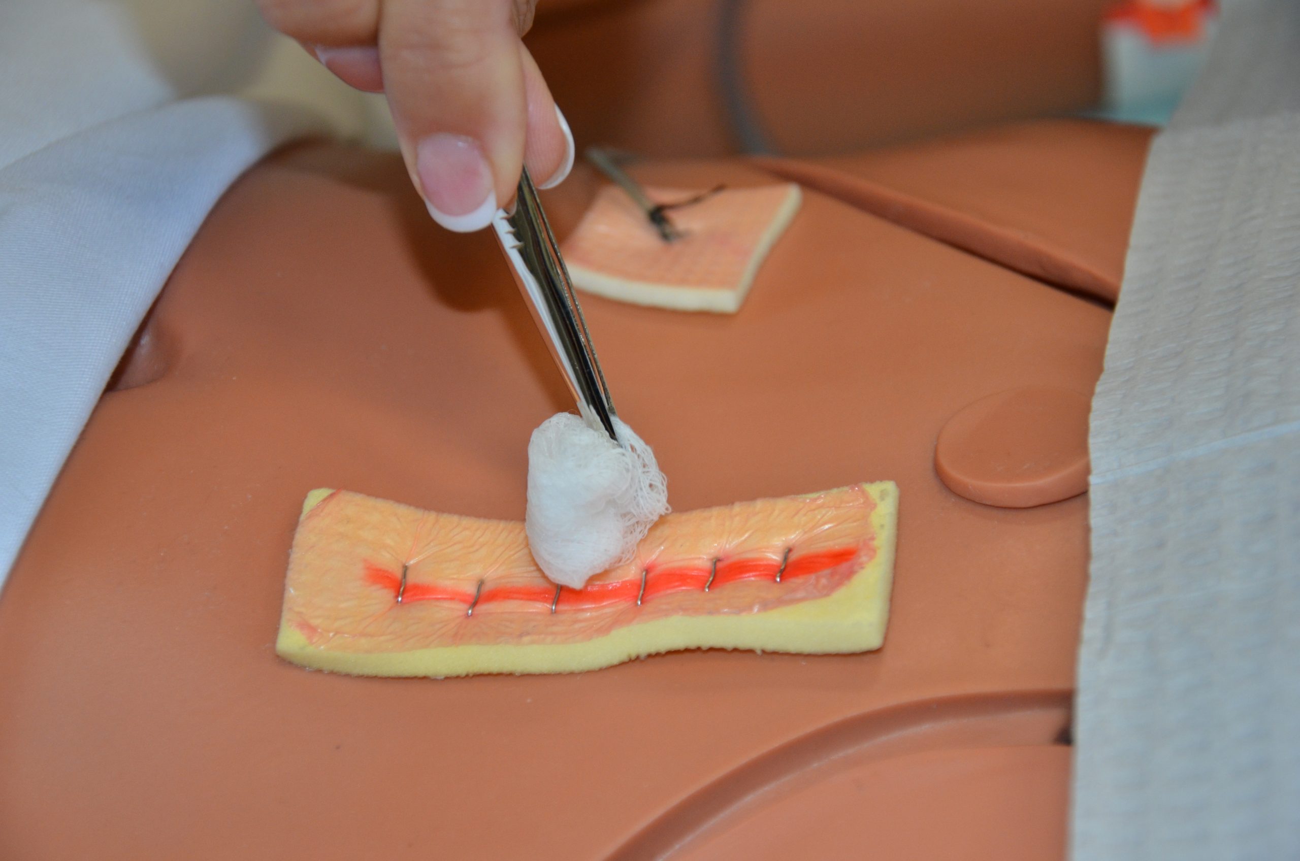 Using a sterile swab or gauze, clean the suture line by starting at the centre and working toward one end.