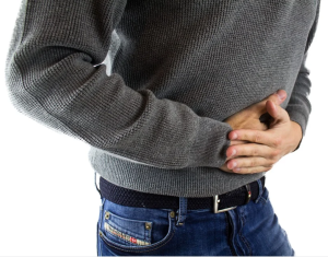 Man presses two hands to abdominal area.