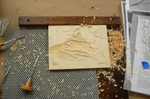 A wood engraving with wood shavings near it