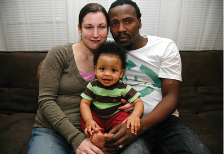 A White woman and a Black man are holding an interracial baby.