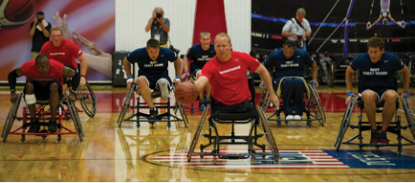 A group of people in wheelchairs playing sports in a gym.