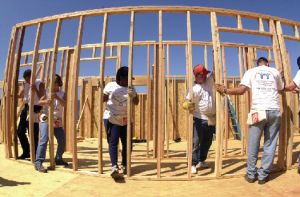 People working together to build the wooden framework of a building.