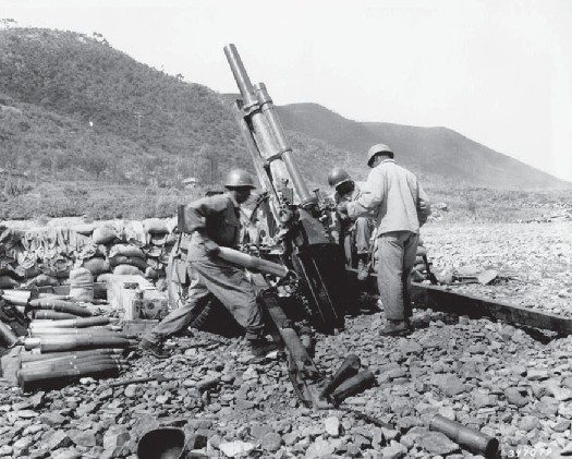 Several soldiers surrounding an artillery piece.
