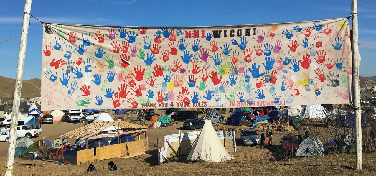 Banner with handprints in front of a camp.