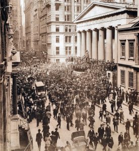 Large crowd of people filling Wall Street.