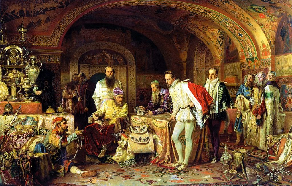 Ivan the Terrible seated at a table surrounded by ten other people in a room filled with tapestry and items made of gold and jewels.