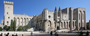 View of the Papal Palace in Avignon France from the large courtyard filled with numerous people