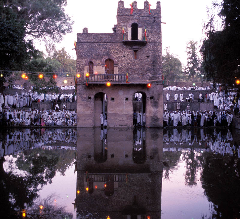 Crowds dressed in white gather at a stone building on the banks of water known as Fasiladas' bath in Gondar, Ethiopia, to celebrate Epiphany