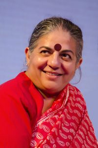 Dr. Vandana Shiva smiling towards camera wearing red sari