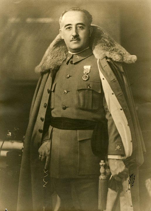 Standing photographic portrait of Francisco Franco in fur collared coat in military dress, looking into camera