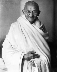 Photographic portrait of Gandhi in white robes looking into camera
