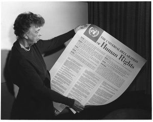 Eleanor Roosevelt standing and holding the Universal Declaration of Human Rights (physically large document)