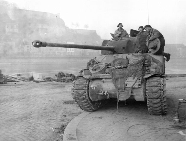 Three British soldiers on top of tank in Namur on the Meuse River