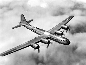 Aerial photograph of large B-29 plane in flight over clouds