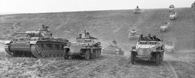 German Panzer tanks advancing over hill and towards camera in Ukraine