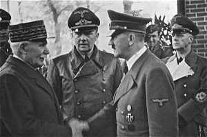 Adolf Hitler shakes hands with Philippe Pétain while three other men look on