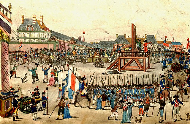 A man holds up the head of someone who has just been guillotined to a large celebratory crowd composed of civilians and French military