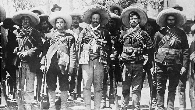 Pancho Villa (center) and members of the Division of the North with bandoliers on their chests and holding rifles