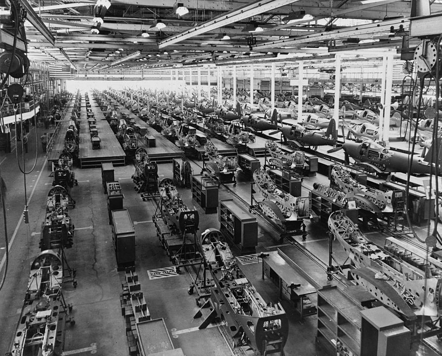 View of an assembly plant with many machines and aircraft in the process of being assembled
