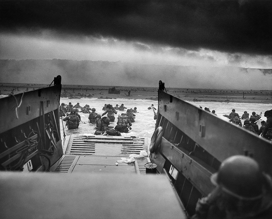 View from the helm of a Higgins Boat as soldiers in water attempt to reach Omaha Beach with dark, heavy smoke and cloud cover