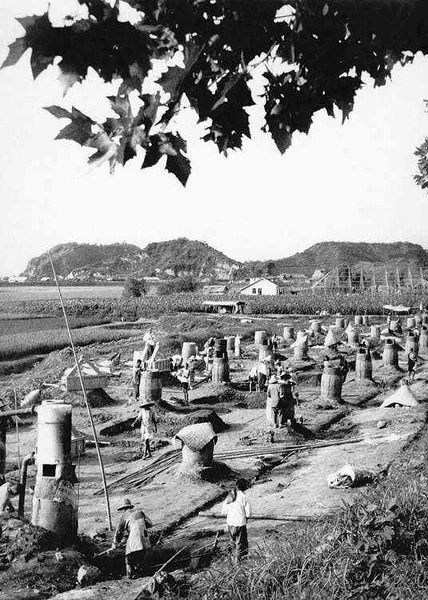 A field filled with tall backyard furnaces used to create steel during the Great Leap Forward